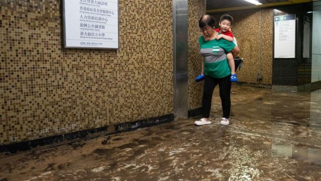 9 月 8 日，香港黄大仙地铁站发生严重水灾，一名儿童被背过泥泞的地面。