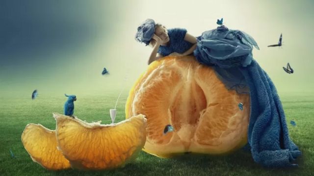 Une femme couchée sur une orange épluchée