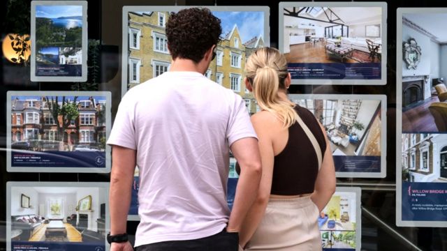 Couple looking in estate agent's window