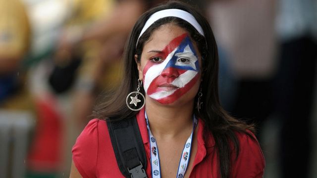 Mujer con la cara pintada con la bandera de Puerto Rico.