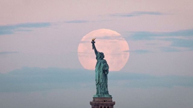 在美國紐約的自由女神像對照下，月亮特別大