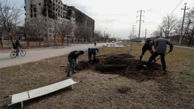 犠牲者を埋葬するため墓を掘る人たち（20日、ウクライナ南東部マリウポリ）