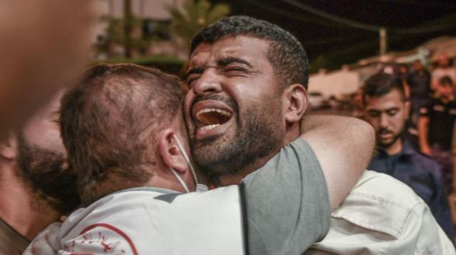 Homens chorando após ataque em Gaza