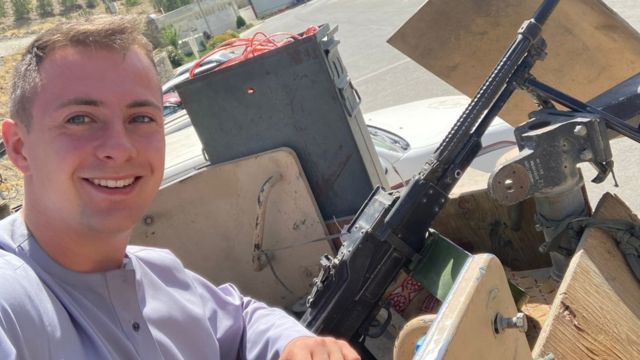 Miles Routledge poses with a gun while in Afghanistan