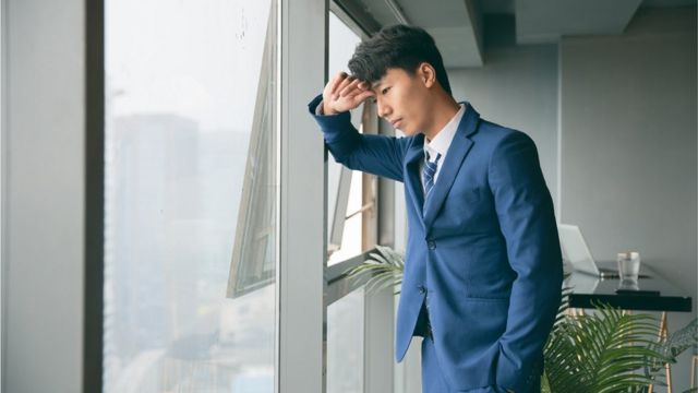 Sad young business man resting by the window