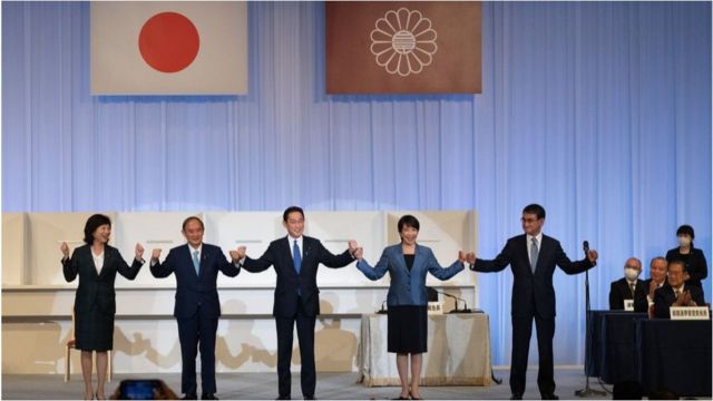 在日本东京，前外相岸田文雄(中)与即将离任的首相菅义伟(左2)及其他候选人野田圣子(左1)、高市早叶(右2)和河野太郎(右1)庆祝赢得自民党领导人选举。