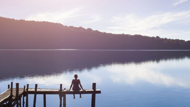 زنی نشسته به تماشای دریاچه
