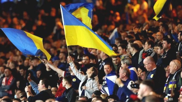 Des supporters écossais brandissant des drapeaux pour soutenir l'Ukraine lors du récent match amical contre la Pologne