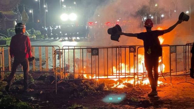 Thai protesters face off with security forces at a burning barricade during an anti-government protest, on a street near the Grand Palace in Bangkok, Thailand, March 20, 2021.