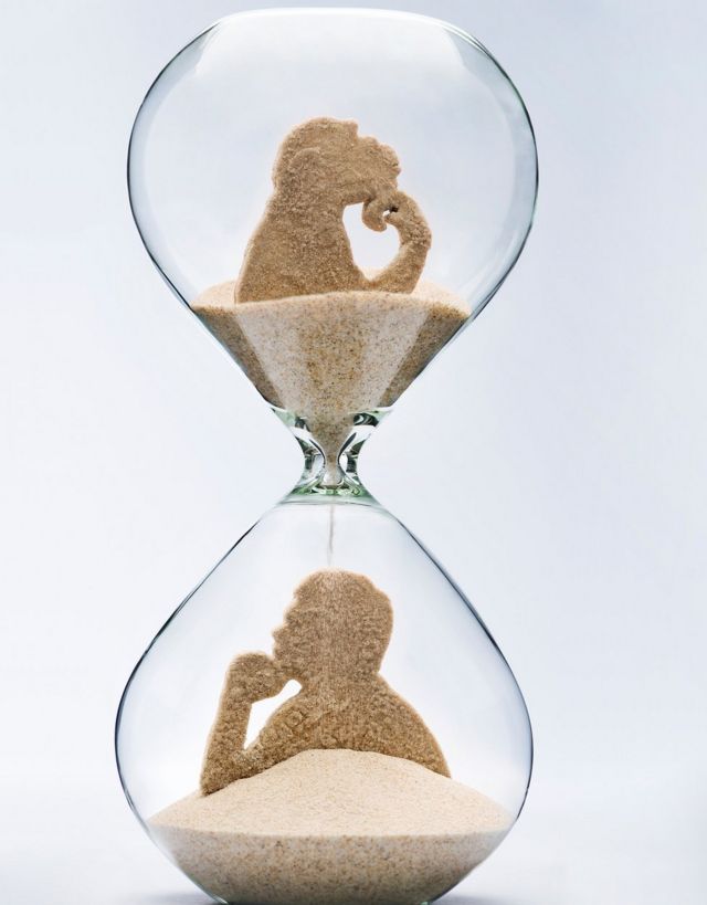 Reloj de arena con figura de mono arriba y de hombre abajo
