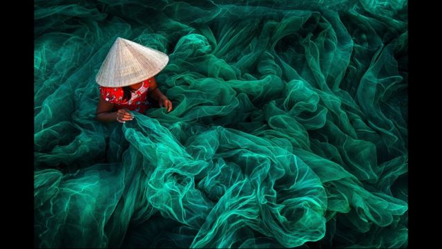 Mujer tejiendo redes de pescar