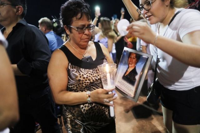Una mujer sostiene una foto de una víctima de El Paso