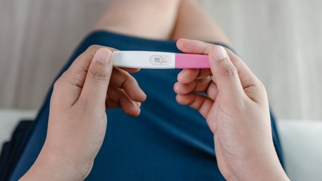 Una mujer sostiene un test de embarazo en sus manos