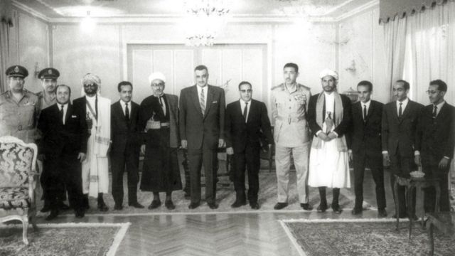 العيني متوسطاً عبدالحكيم عامر وعبدالناصر الذي يليه عبدالرحمن الإرياني رئيس اليمن الأسبق وحولهما عدد من كبار القادة اليمنيين والمصريين عام 1965