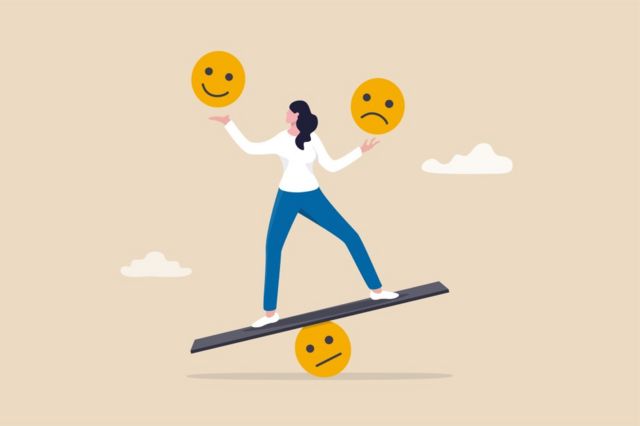 A woman juggling a sad face and a small face on a seesaw