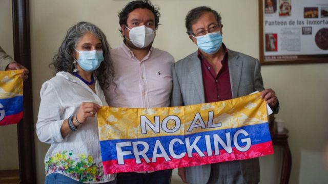 Gustavo Petro junto a otras dos personas con un cartel que dice "no al fracking".