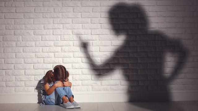 La sombra de una mujer gritándole a una niña asustada.
