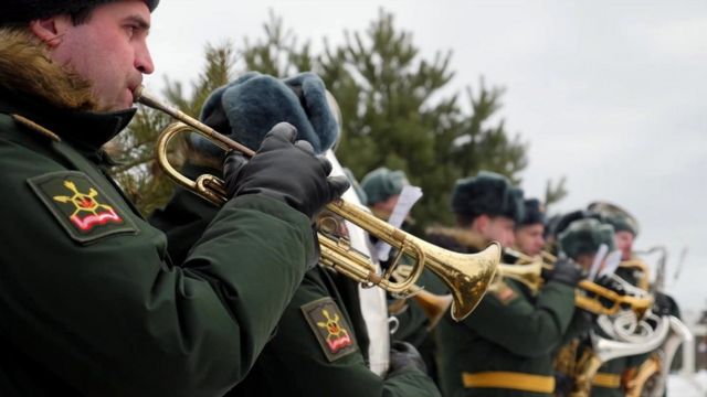 Militares russos tocam instrumentos de sopro durante funeral