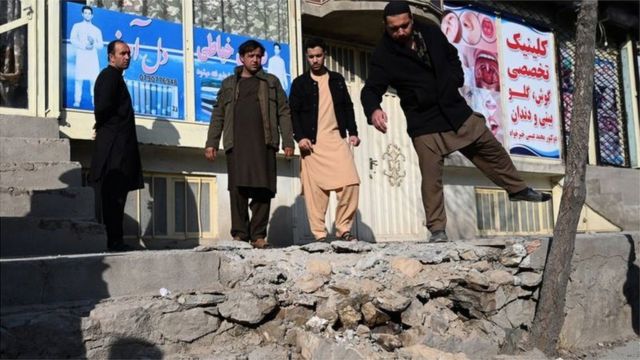 أشخاص يتفقدون جانبا من الدمار