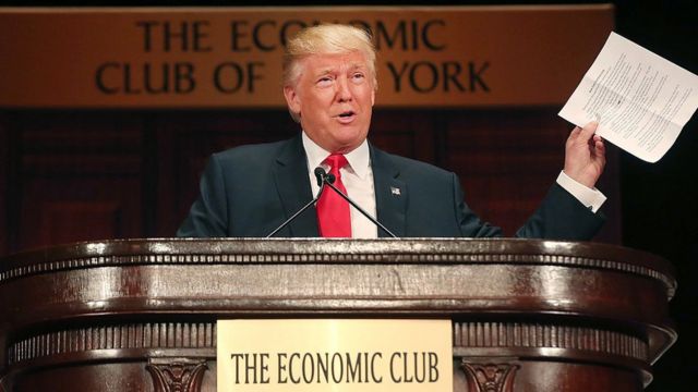 Trump frente a un estrado que Dice "The Economic Club"