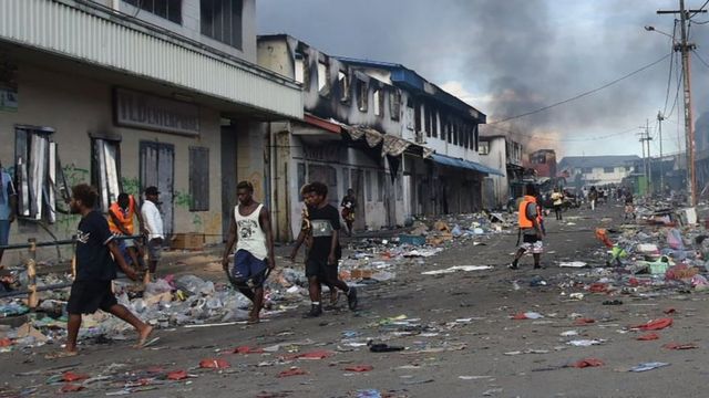 People walk through the Chinatown district of Honiara on the Solomon Islands on November 26, 2021