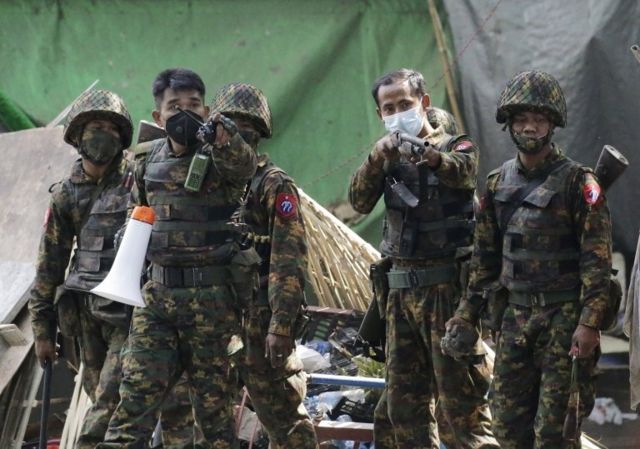 A group of soldiers pointing a gun.