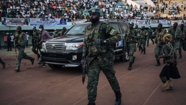 Rais wa Jamuhuri ya Afrika ya kati Faustin Archange Touadéra akisindikizwa na walinzi wa raia wa Rwanda na Walinda amani wa Umoja wa Mataifa