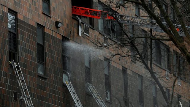 Personal de emergencia responde a un incendio en el Bronx, New York. Colocan una escalera en una ventana del edificio afectado