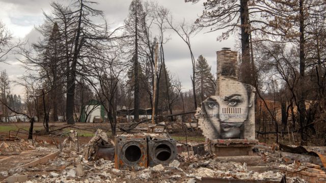 Casas destruidas por los incendios forestales en Paradise, California. En un muro se ve un grafiti con el rostro de una joven.