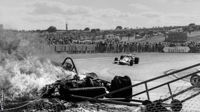 Jacky Ickx, Jochen Rindt, Ferrari 312B, Grand Prix of Spain, Circuito del Jarama, 19 April 1970. Jochen Rindt goes by the burning Ferrari of Jacky Ickx following the first lap accident. (Photo by Bernard Cahier/Getty Images)