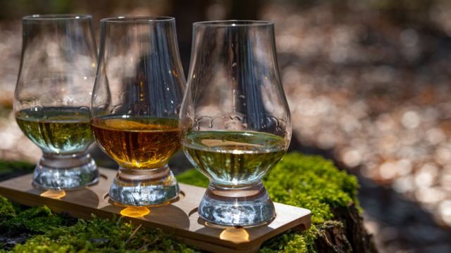 Виски в стаканах на фоне травы.