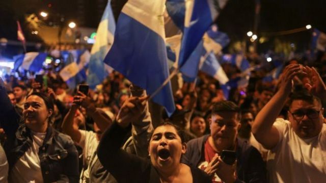 Multidão celebrando em local público à noite