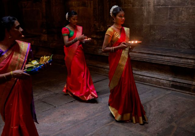 کلمبو، سریلانکا؛ سه دختر هندو چراغ‌های روغنی به دست، به سمت برگزاری مراسم پیاده‌روی می‌کنند