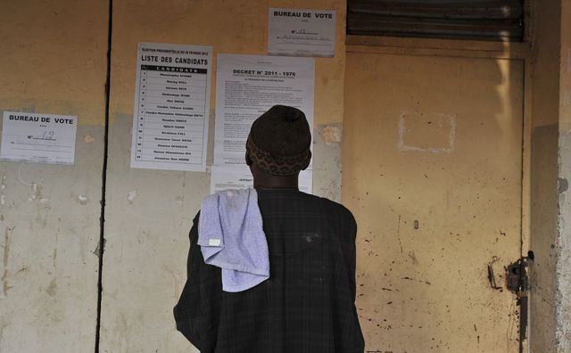 Un homme se tient devant la porte fermée d'un bureau de vote à Dakar, jour du premier tour de l'élection présidentielle le 26 février 2012. 