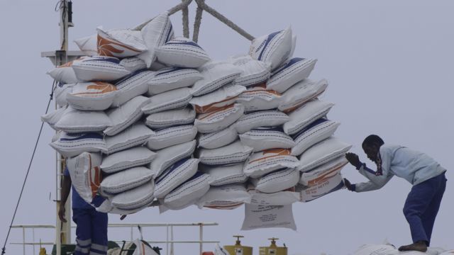 Sejumlah pekerja menurunkan tumpukan karung berisi beras di Pelabuhan Tenau Kupang, NTT, Rabu (18/01/2023)