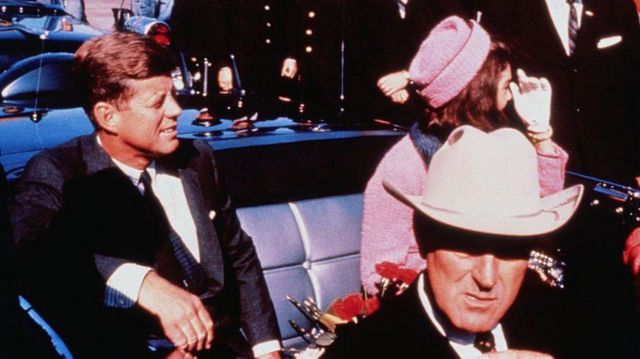 صورة لحاكم ولاية تكساس جون كونالي في المقدمة بينما يجلس جون إف كينيدي وزوجته جاكي كينيدي في المقعد الخلفي.