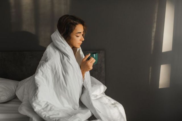mulher com cobertor, com febre