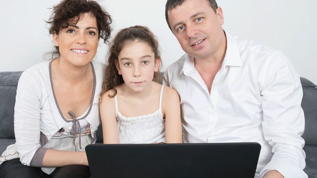 Family sitting in front of laptop