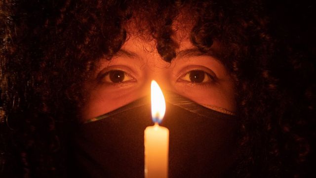 Une femme tient une bougie lors d'une manifestation à Brasilia.