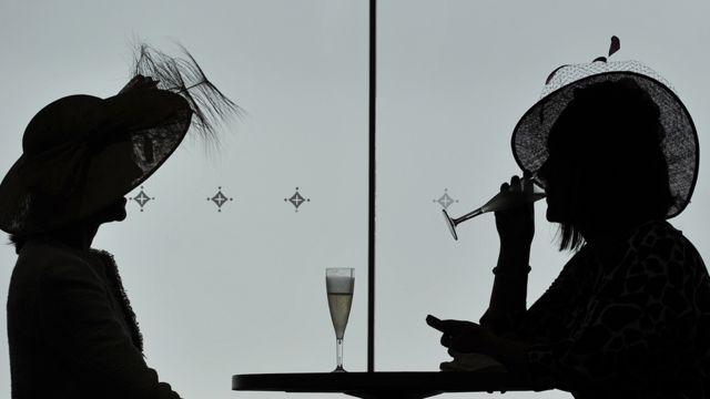 Silhueta de duas mulheres bebendo champagne