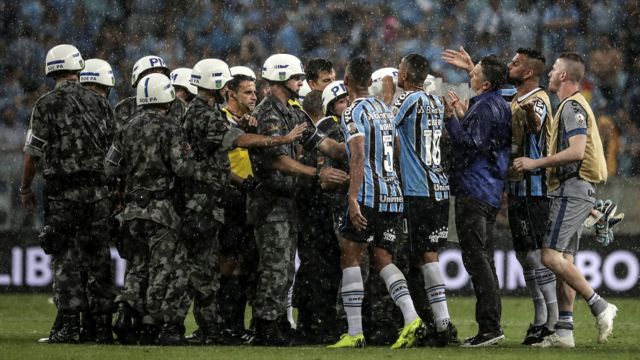 Los jugadores de Gremio rodean al árbitro Andrés Cunha.