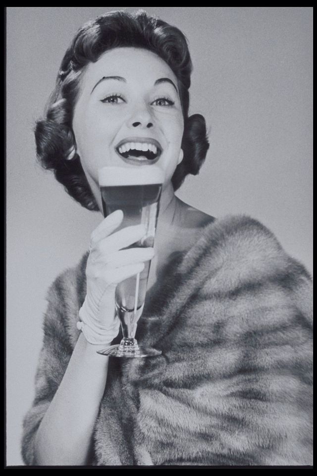 Mulher segurando copo de cerveja em foto da década de 1950