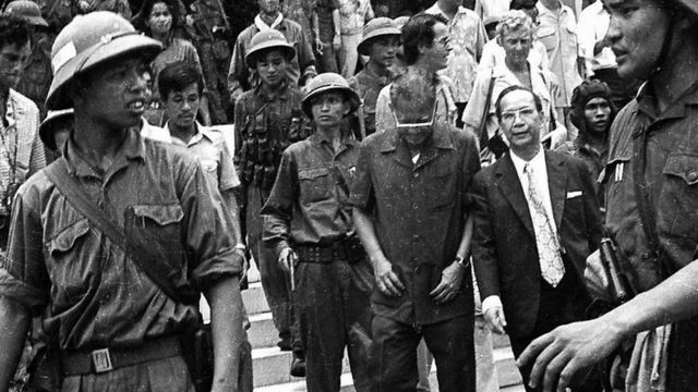Tổng thống Dương Văn Minh (đeo kính, cúi đầu) bị bộ đội cộng sản đưa đi