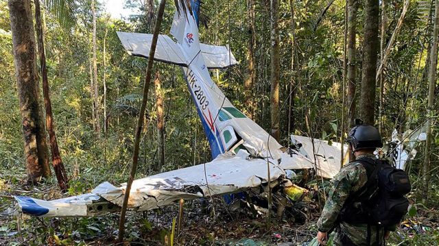 Destroços de avião na floresta, observados por soldado