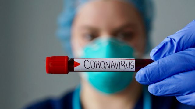 Una médica frente a una muestra de coronavirus