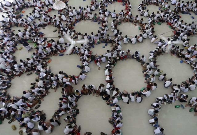 مجموعة من الطلاب يقرأون القرآن في حلقات خلال شهر رمضان في أحد ميادين إندونيسيا.