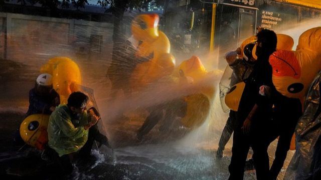 Protesters use inflatable rubber ducks as shields to protect themselves from water cannons during an anti-government protest in Bangkok, Thailand, on November 17, 2020.