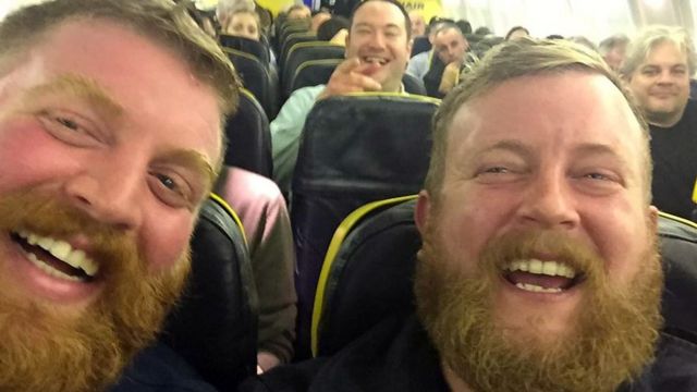 Two men who look very similar taken on a plane