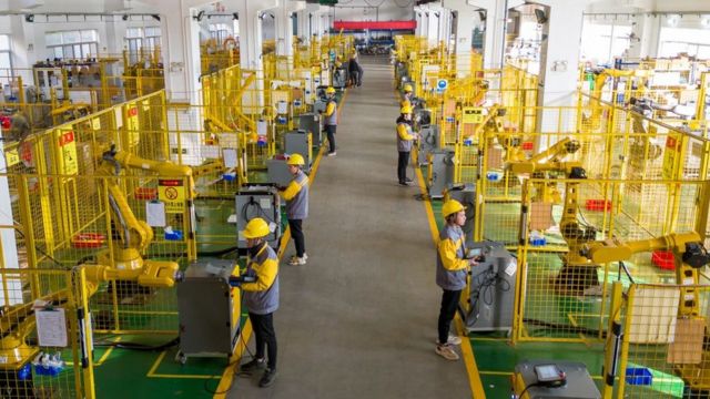 工人大量感染可能影响制造业的开工率。图为12月12日江苏一家工业机器人制造企业的车间。(photo:BBC)
