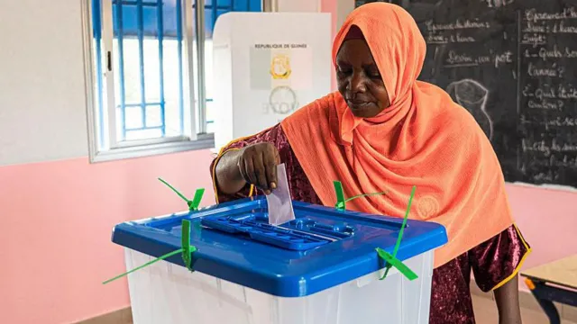 A voter casts her ballot in Guinea